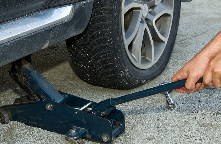 Image of a jack being used on a flat tire